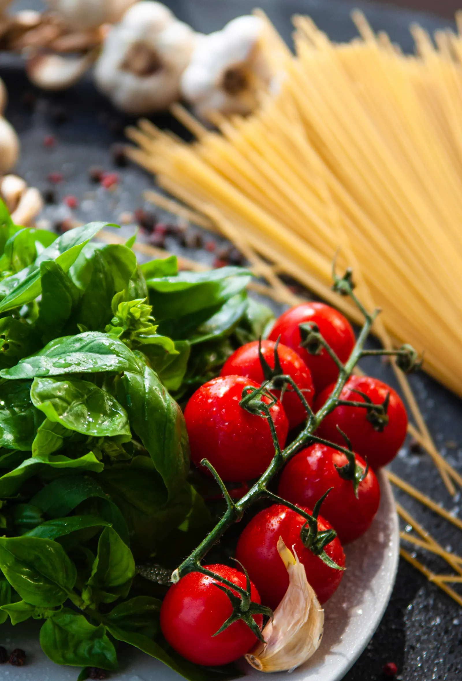 Pomodori, basilico e pasta su un piano di ardesia